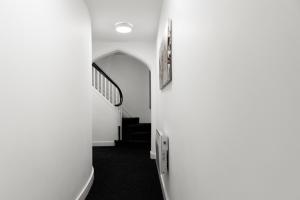 a hallway with white walls and a stair case at Ledger Loft in Brierley Hill