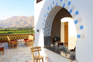 een keuken met een boog en een patio met bergen bij Calm moon nights hostel in Al Aqālitah