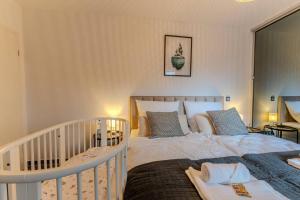 a bedroom with a large bed and a crib at Luxus am Park Altstadt-Barrierefrei-Parkplatz in Wetzlar