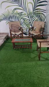 um quarto com relva verde e cadeiras e uma parede em Departamento de playa con piscina en estreno em La Punta