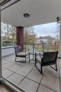 a balcony with two chairs and a table on a balcony at Luxus am Park Altstadt-Barrierefrei-Parkplatz in Wetzlar