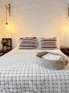 a bed with a basket on top of it at Papoila in Grândola