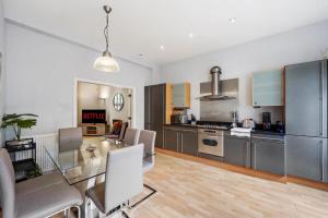 a kitchen with a glass table and stainless steel appliances at The Elegant 3 Bed on the Stray! in Harrogate