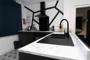 a black and white kitchen with a sink at Gold Reserve Retreat in Brierley Hill