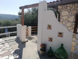 uma parede branca com dois vasos verdes em B&B Borgo Degli Ulivi em Vieste