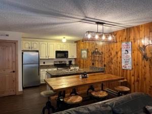 a kitchen with a table and a stainless steel refrigerator at Silverado II in Winter Park