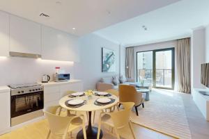 a kitchen and living room with a table and chairs at La Voile Building 1 - Locations in Dubai