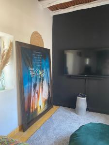 TV a/nebo společenská místnost v ubytování Les jardins de Silona, piscine chauffée