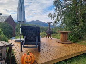 a wooden deck with a pumpkin and a stove at Polar Cottage House Bodø in Nygårdsjøen