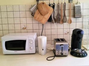 un bancone cucina con forno a microonde e tostapane di Appartement spacieux près du Diamant avec jardin privatif a Le Diamant