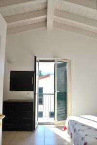 a bedroom with a bed and a flat screen tv at Appartamenti Vacanza in Roseto degli Abruzzi