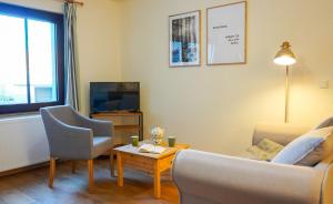 - un salon avec un canapé, une table et une télévision dans l'établissement Apartment mit Herz im Harz, à Meisdorf
