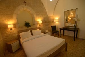 a bedroom with a bed and a desk and a mirror at St. George’s Cathedral Pilgrim Guesthouse – Jerusalem in Jerusalem