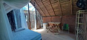 ein Schlafzimmer mit einem Bett und einem Tisch in einem Zimmer in der Unterkunft MALOCA - Chalés Rusticos in Ilha de Boipeba