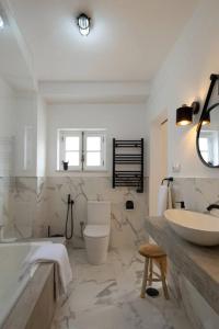 a bathroom with a tub and a sink and a toilet at Apartamento Aires - Trafaria in Trafaria
