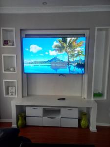 a living room with a flat screen tv on a wall at Amreff Nyumbani villas in Kitengela 