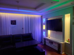 un soggiorno con divano e TV a schermo piatto di Amreff Nyumbani villas a Kitengela 