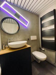 a bathroom with a white sink and a toilet at HappyLivingApartments in Villach