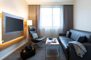 a hotel room with a couch and a tv at Moxy London Excel in London