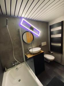 a bathroom with a tub and a sink and a mirror at HappyLivingApartments in Villach