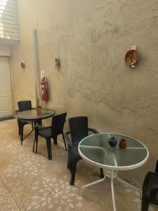 Pokój z dwoma stołami i krzesłami oraz ścianą w obiekcie Rutero w mieście La Serena