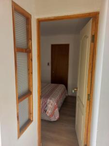 sypialnia z łóżkiem i drzwiami prowadzącymi do pokoju w obiekcie Rutero w mieście La Serena