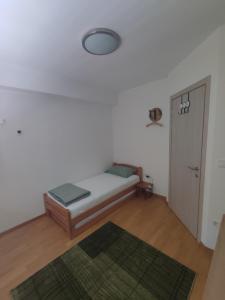 um pequeno quarto com uma cama e uma porta em Cozy Urban Apartment in Skopje! em Skopje