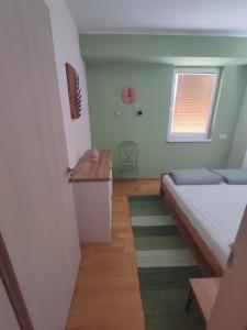 um pequeno quarto com uma cama e uma janela em Cozy Urban Apartment in Skopje! em Skopje