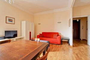 a living room with a red couch and a television at Appartamento - Vatican in Rome
