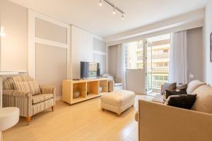 a living room with a couch chair and a tv at SEQ - Sequoia Alphaville By Anora Spaces in Barueri