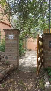 Una puerta y una valla con un cartel. en Residencia zona sierras chicas (casa) El talar en Mendiolaza