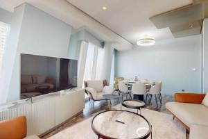 een woonkamer met een tafel en stoelen en een televisie bij Damac Heights - Locations in Dubai