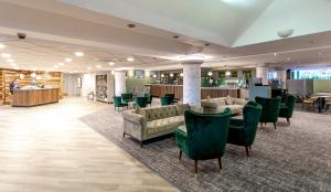 a lobby with couches and chairs and a bar at Cedar Court Hotel Huddersfield in Huddersfield