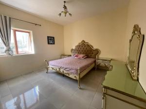 a bedroom with a bed and a mirror at لايجار ٢ غرفه وصاله باقاسميه الشارقه in Sharjah