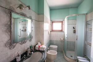 bagno con lavandino, servizi igienici e specchio di Via della musica a Vicchio