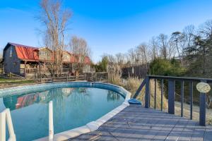 a swimming pool on a deck with a house at Cozy Cottage with Pool Btwn Knoxville and Pigeon Forge in Strawberry Plains
