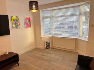 a living room with a window and a sign on the floor at Cool 2 Bed Hornchurch House, Arcade Games, Free Parking in Hornchurch