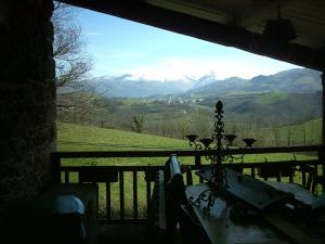 een veranda met uitzicht op een bergketen bij La Coquille Napoléon in Saint-Jean-Pied-de-Port
