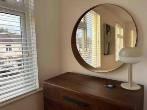a mirror on top of a dresser in a room at Cool 2 Bed Hornchurch House, Arcade Games, Free Parking in Hornchurch