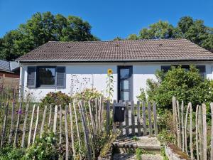 une maison blanche avec une clôture devant elle dans l'établissement Chambre au calme à Ramillies - chez Ben, à Ramillies