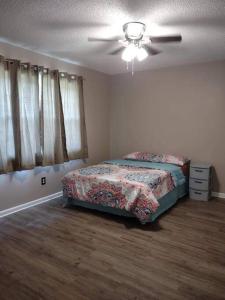 una camera con letto e ventilatore a soffitto di Lovely 4 BR Home Near Fort Johnson-14 Minute Drive a Leesville