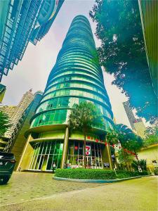 een hoog gebouw met een boom ervoor bij vortex suites klcc Adela Suites in Kuala Lumpur