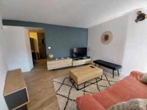 een woonkamer met een bank en een tv bij Sunset APPART in Brignoles