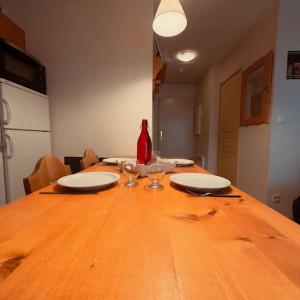 a wooden table with plates and wine glasses on it at Le NID D'ARAN in Luchon