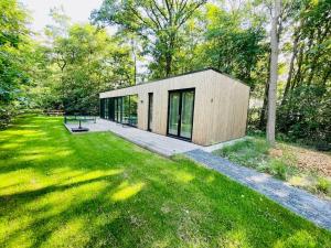 a small house in the middle of a yard at Chalet goudmeer LUXURY AIRCO WIFI 3 bedrooms 2 bathrooms in Oosterwolde