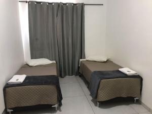 a room with two beds and a curtain at Hotel Vila Real Dourados in Dourados +13 photos