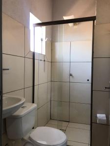 uma casa de banho com um chuveiro, um WC e um lavatório. em Hotel Vila Real Dourados em Dourados