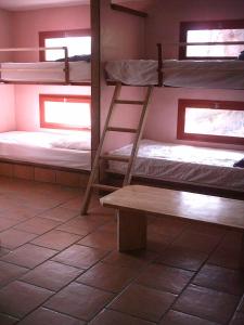 Cette chambre comprend 3 lits superposés et un banc. dans l'établissement La Coquille Napoléon, à Saint-Jean-Pied-de-Port