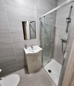a bathroom with a sink and a shower and a toilet at Luxurious Ensuite in Edgware