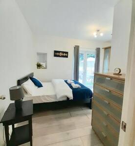 a bedroom with a bed and a dresser at Luxurious Ensuite in Edgware